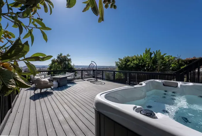 backyard deck with hot tub, fire pit, and seating area to enjoy the city views and sunset!