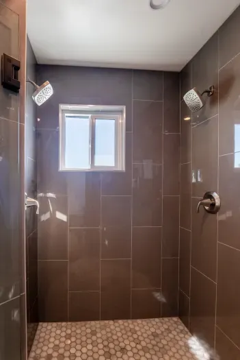 Dual shower head in full private downstairs bathroom for the primary bedroom.