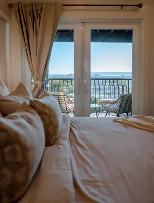 Downstairs bedroom with TV and private balcony with city views