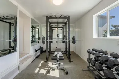 Gym with bench press, dumbbells.