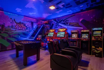 Minecraft-Themed Game Room: A row of racing arcade cabinets and a foosball table light up beneath the pixel-art village skyline!