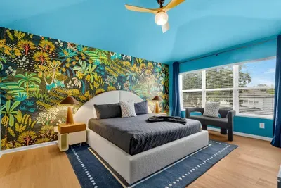 Master Bedroom: Tropical leaf mural and a vibrant teal ceiling set a relaxing, statement-making mood!