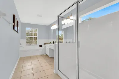 Bright spa-like bathroom with soaking tub, double vanity, and glass shower