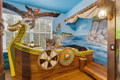 How to Train your Dragon Themed Kids' Room: Sail off in a Viking longship bed with a dragon-head prow and shields, set against a seaside cliff mural!
