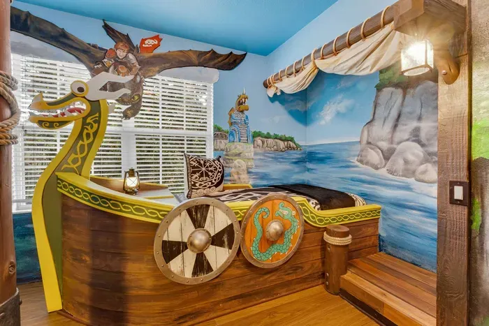 How to Train your Dragon Themed Kids' Room: Sail off in a Viking longship bed with a dragon-head prow and shields, set against a seaside cliff mural!