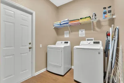 Laundry Room: Full-size LG washer and dryer with detergent, fabric softener, and dryer sheets provided, plus an iron, ironing board, drying rack, and colorful pool towels ready for the lanai!