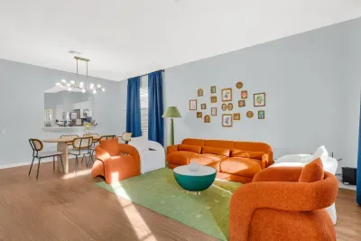 Bright designer living room with bold seating and open dining area