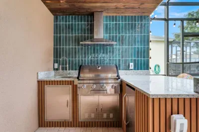 Summer Kitchen: A built-in grill and sleek teal tile backsplash make outdoor cooking a breeze!