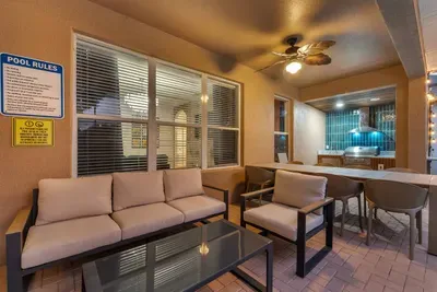 Screened Patio: Warm evening lighting sets the mood in the plush sofa seating area beside the summer kitchen!