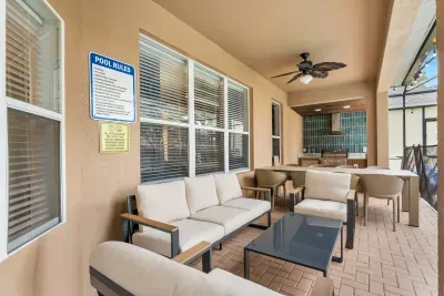Covered patio with cozy seating, dining area, and built-in grill