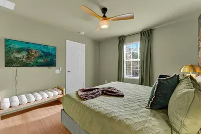 Bedroom 2: Coastal wall art and a cozy shell-topped bench complete this serene green escape!