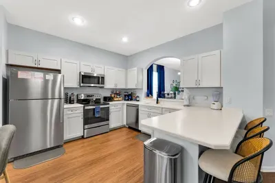 Full Kitchen: Crisp white cabinetry, stainless steel appliances, and a breakfast bar with stool seating!