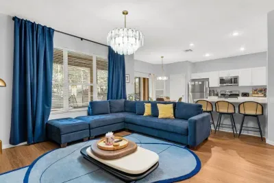 Second Living Area: Open-concept lounge with a deep blue sectional flowing right into the kitchen!