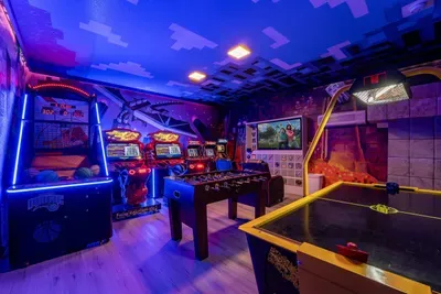 Minecraft-Themed Game Room: Blocky pixel-art murals set the scene for arcade basketball, foosball, and air hockey under neon lights!