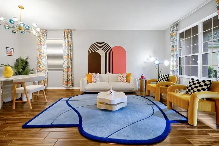 Our living room, adorned with vibrant colors, is filled with board games and a dining table, creating a space perfect for family fun.