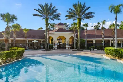 Resort-style pool and tropical clubhouse with sunny palm-lined views
