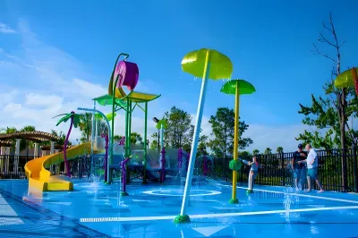 Colorful family splash pad with slide and fun water features