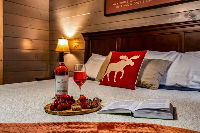 Cozy cabin-style bedroom with wine, fruit, and warm rustic charm