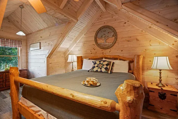 Rustic cabin bedroom with vaulted wood ceilings and handcrafted log bed