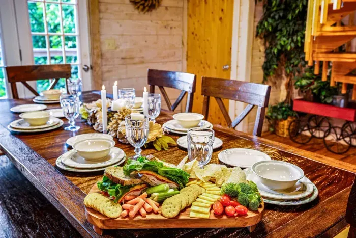 Rustic dining space with a large table, cozy decor, and inviting meal setup