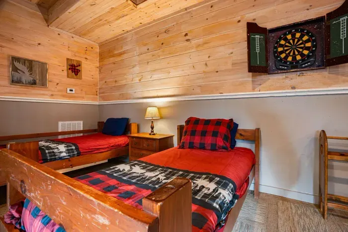 Cozy rustic twin room with cabin decor and a fun dartboard