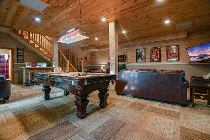 Rustic game room with pool table, leather seating, and cozy lodge vibes