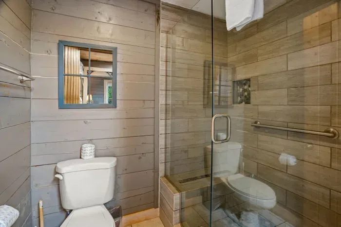 Rustic bathroom with glass walk-in shower and warm wood accents