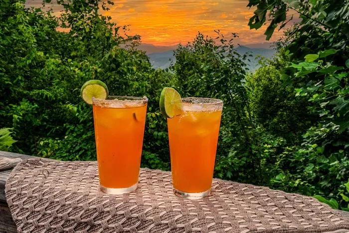 Sunset cocktails on a private deck with lush forest and mountain views