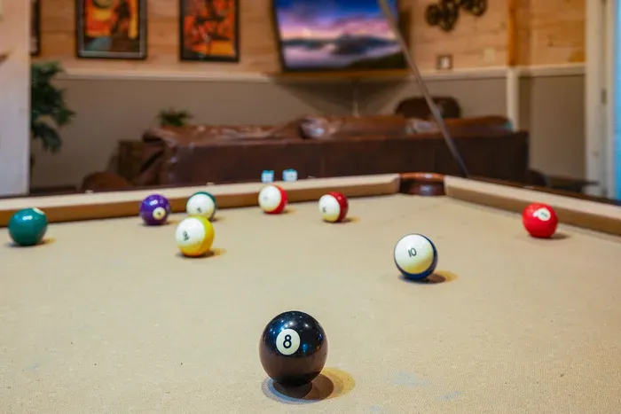 Cozy game room with pool table and lounge seating for guest fun