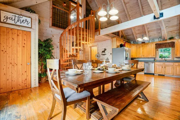 Rustic open-concept cabin with loft, full kitchen, and spacious dining area