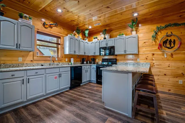 Spacious cabin kitchen with granite tops, bar seating, and warm wood charm