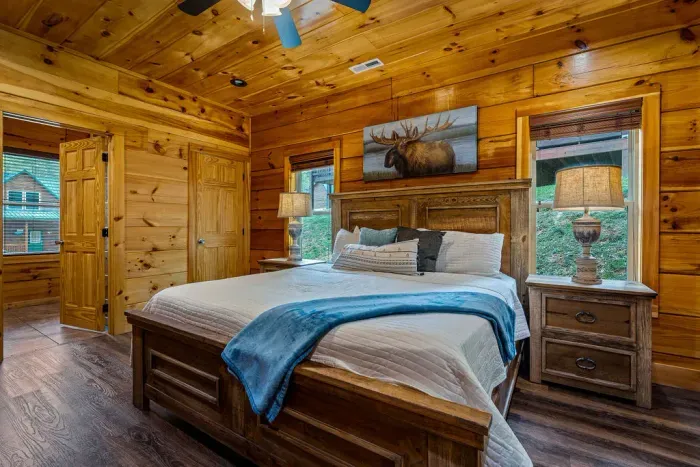 Cozy king suite with rustic wood, natural light, and serene views.