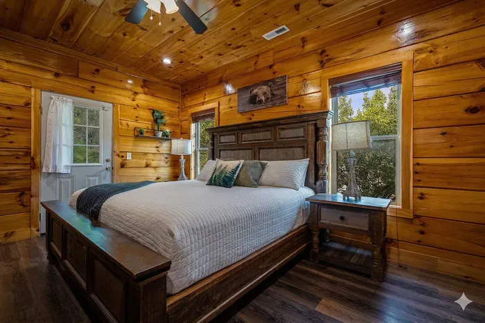 Cozy cabin bedroom with king bed, forest views, and warm wood finishes