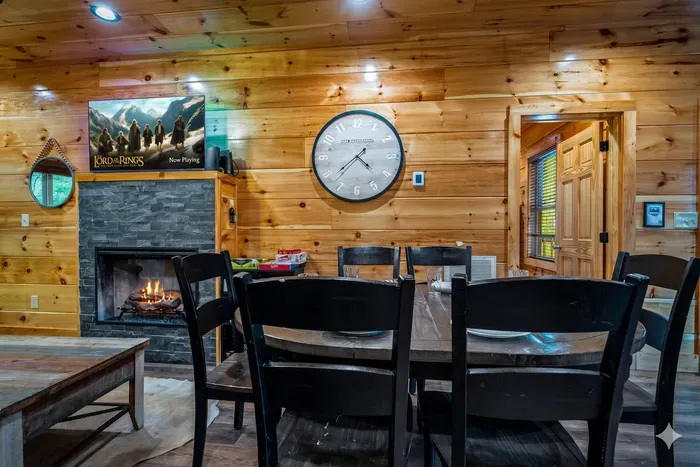 Cozy cabin dining by stone fireplace, farmhouse table, and games