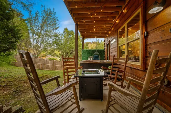 Covered patio with rockers, fire table, and private hot tub retreat.