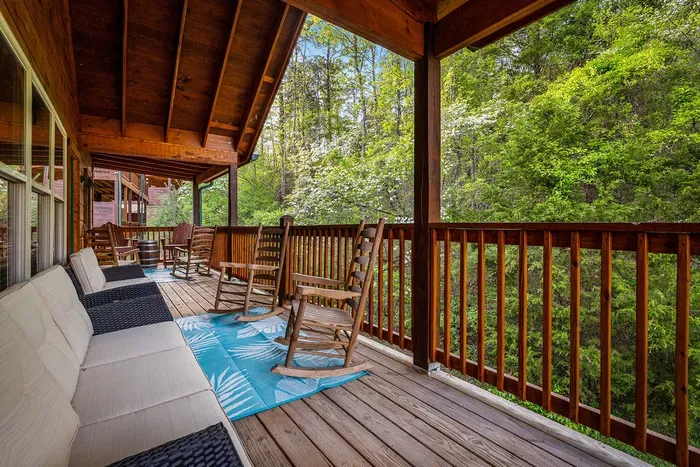 Covered forest-view deck with rockers and lounge seating—relax & unwind
