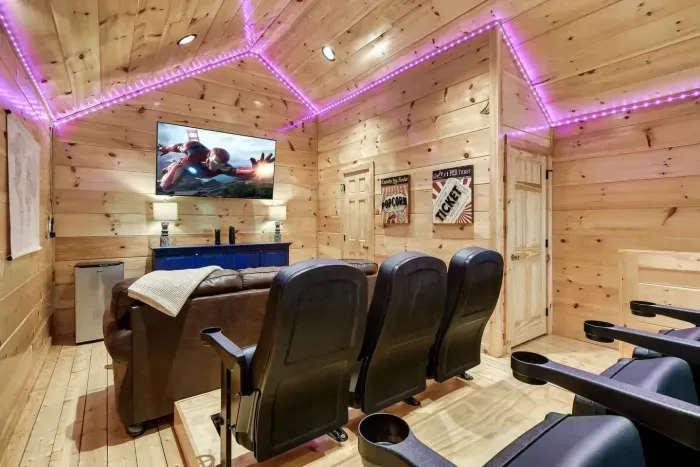 Movie area with large screen smart TV, movie seating, mini fridge and LED lighting 