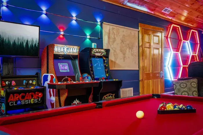 Colorful game room with pool table, arcades & LED glow. NBA Jam, multicade, Galaga