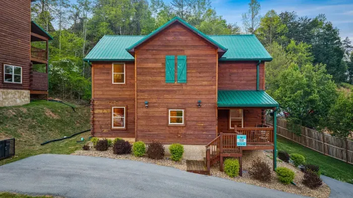 Charming mountain cabin with green metal roof, porch, and easy parking