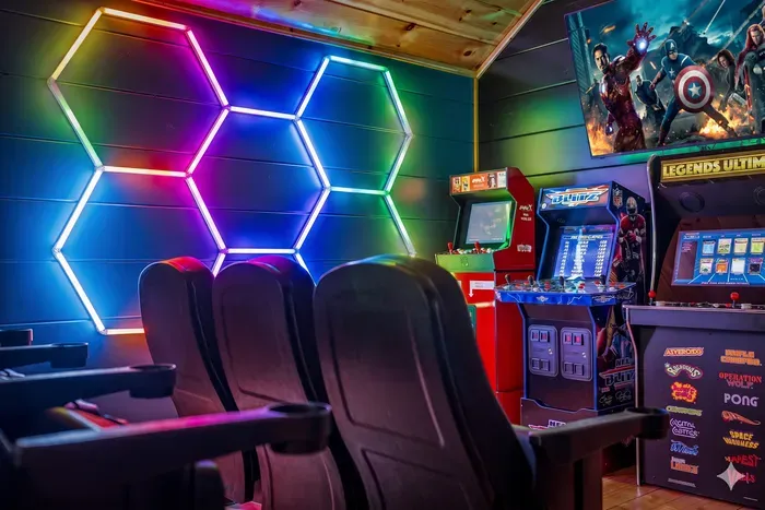 Neon-lit game room with classic arcades and theater seating—family fun!