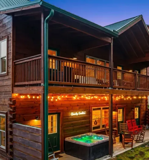 Cozy timber cabin with hot tub, string lights, and two covered decks