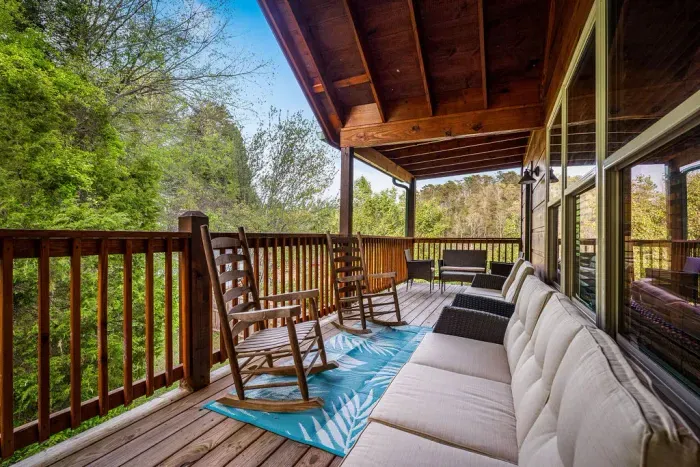 Covered forest-view deck with rocking chairs and cushy seating