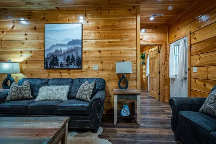 Cozy log cabin lounge with leather sofas and warm wood finishes.