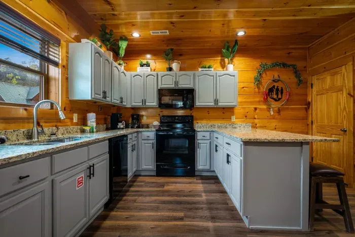 Cozy cabin kitchen with granite, U-shaped layout, bar seating & coffee nook