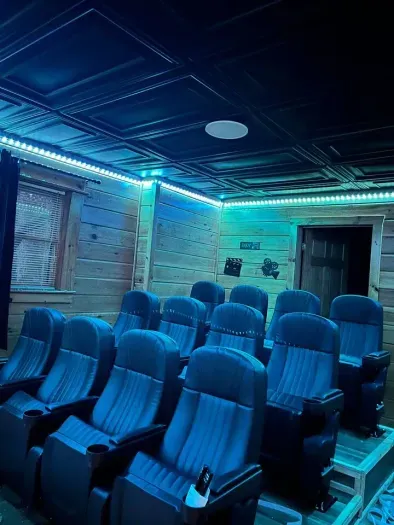 Dedicated movie room with 75” TV, LED lighting, movie decor and private bathroom 