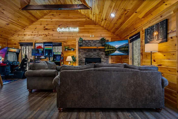 Cozy timber lounge with fireplace, big TV, and arcade game corner