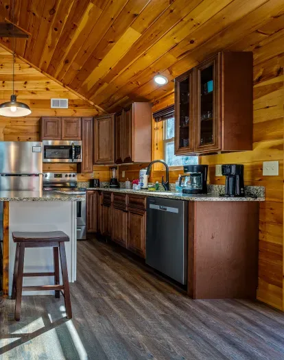 Warm cabin kitchen with granite, stainless, island seating & coffee bar