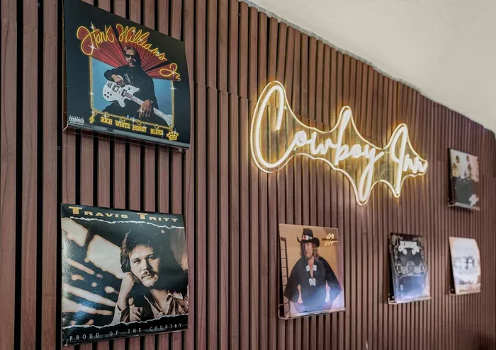 Music-themed accent wall with neon sign and rustic western charm