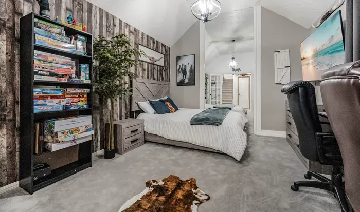 Cozy vaulted bedroom with workspace, games, and stylish rustic touches