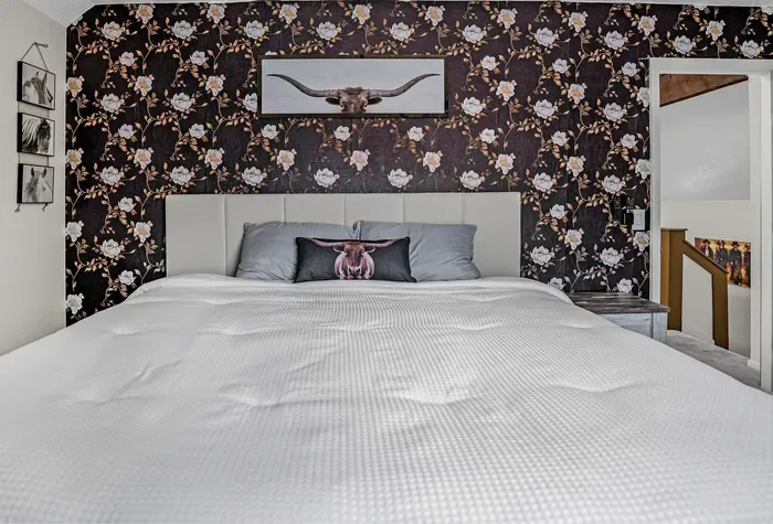 Cozy king bedroom with bold floral wall and stylish western decor